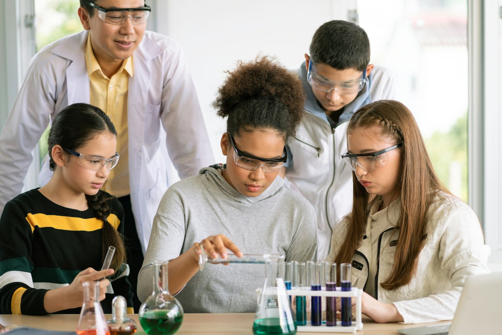 Students working together on a science experiment with a teacher