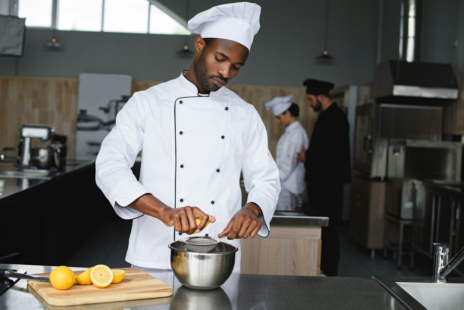 african american chef squeezing lemons at restaurant kitchen