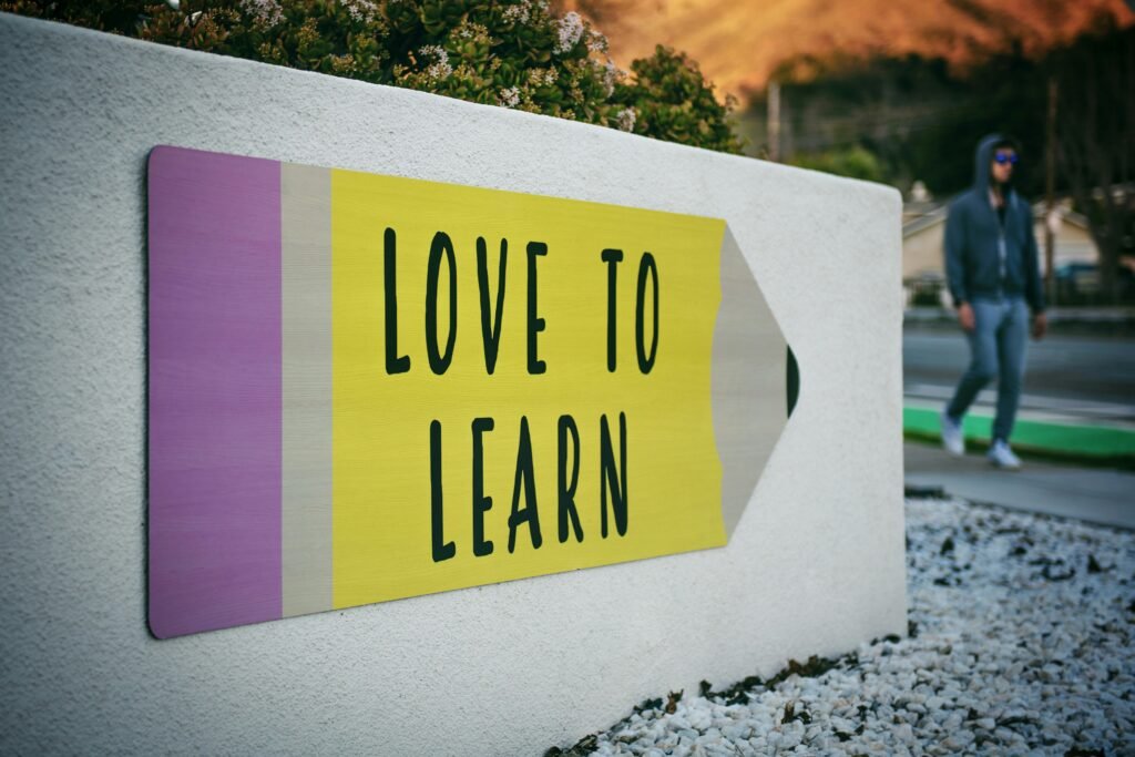 Sign shaped like a pencil that reads "Love to Learn," symbolizing motivation and microlearning for teachers through short, meaningful learning moments.