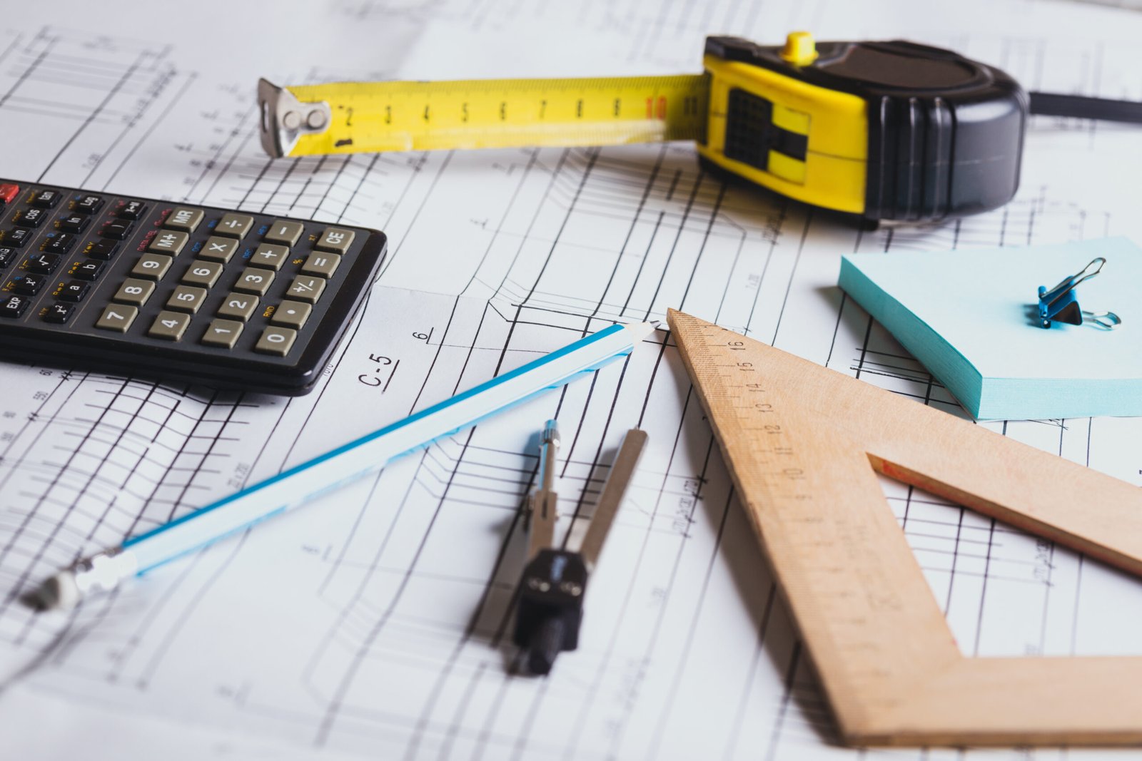 Architectural drawings with a calculator, ruler, and measuring tape