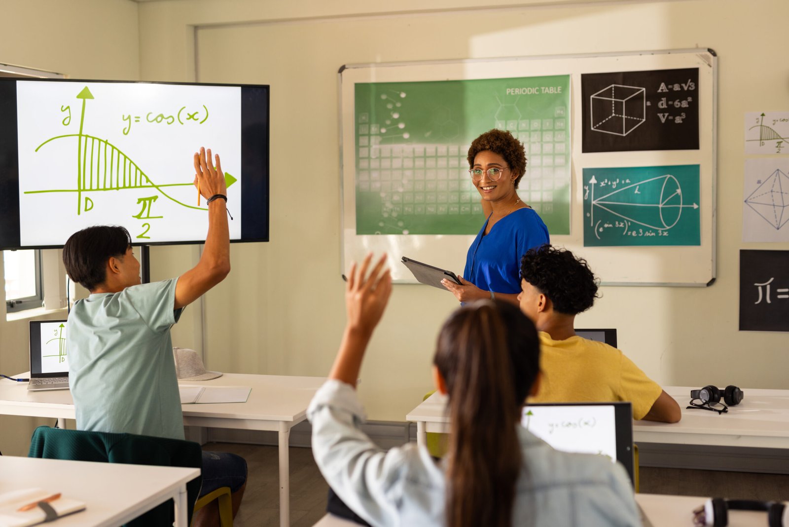 Students raising their hands during a classroom lesson