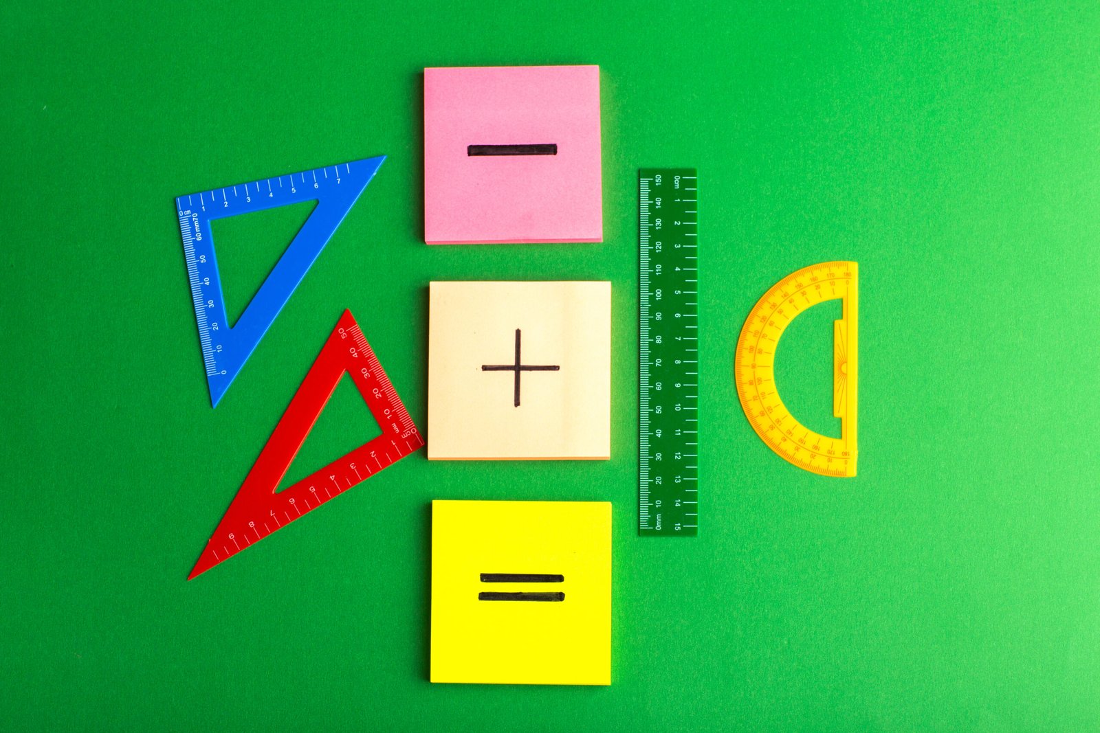 Mathematical symbols and geometry tools on a green surface